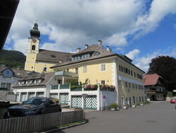 Denkmalgeschütztes ehemaliges Hotel Goldenes Schiff und Pfarrkirche Sankt Bartholomäus in Unterach am Attersee.JPG
